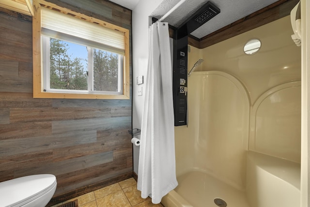 7028 Merrio Rd, Grayling, MI 49738 - full bathroom featuring curtained shower, toilet, tile patterned floors, and wooden walls