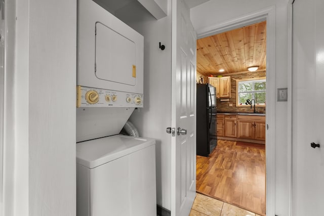 7028 Merrio Rd, Grayling, MI 49738 - laundry area with stacked washing machine and dryer, wood ceiling, and light wood-type flooring
