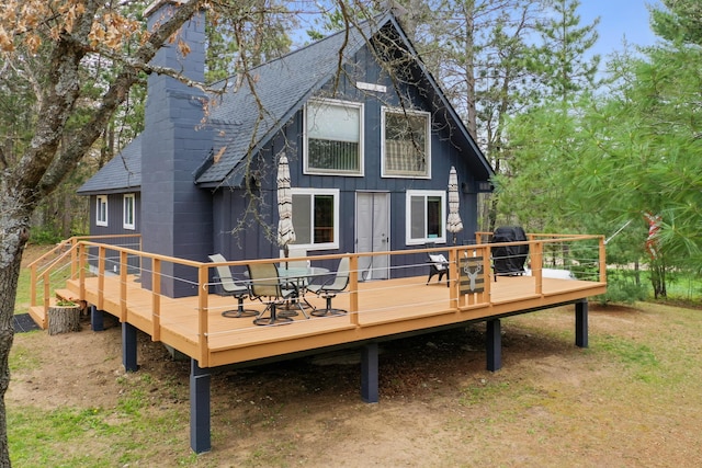 7028 Merrio Rd, Grayling, MI 49738 - back of house with roof with shingles, a wooden deck, and a chimney