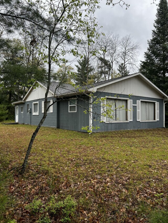 10181 E Carter Lake Rd, Saint Helen, MI 48656 - view of side of home with a lawn