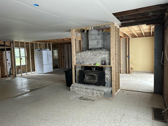 2883 M-18, Roscommon, MI 48653 - below grade area with a wood stove and freestanding refrigerator