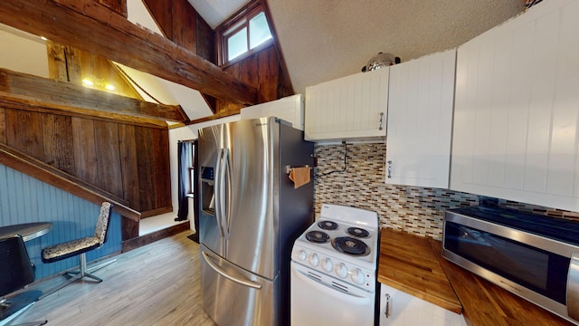 605 Cedar Ave, Houghton Lake, MI 48629 - kitchen with appliances with stainless steel finishes, tasteful backsplash, light wood-type flooring, lofted ceiling, and white cabinets