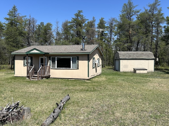 269 Dixson Dr, Grayling, MI 49738 - rear view of property featuring a lawn, roof with shingles, and view of wooded area