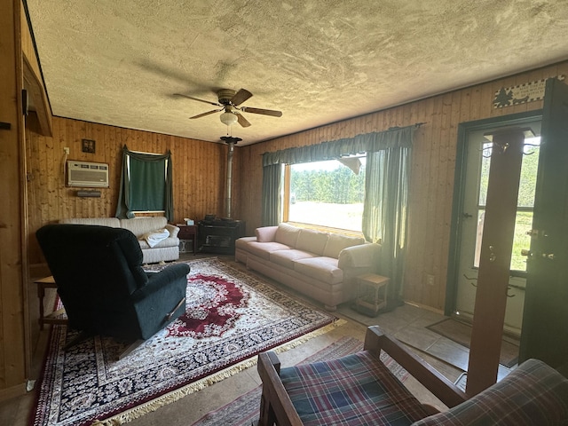 269 Dixson Dr, Grayling, MI 49738 - living area with a wall mounted air conditioner, a ceiling fan, a textured ceiling, and wood walls