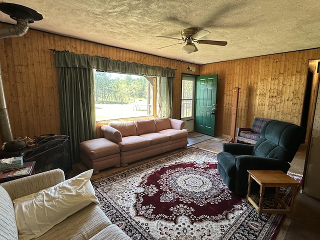 269 Dixson Dr, Grayling, MI 49738 - living area featuring wood walls, ceiling fan, and a textured ceiling