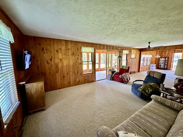 370 W Park Dr, Grayling, MI 49738 - living room with a textured ceiling, carpet floors, ceiling fan, and wood walls