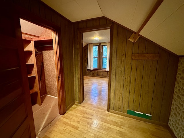 370 W Park Dr, Grayling, MI 49738 - corridor with vaulted ceiling, light wood-style floors, wooden walls, wallpapered walls, and baseboards