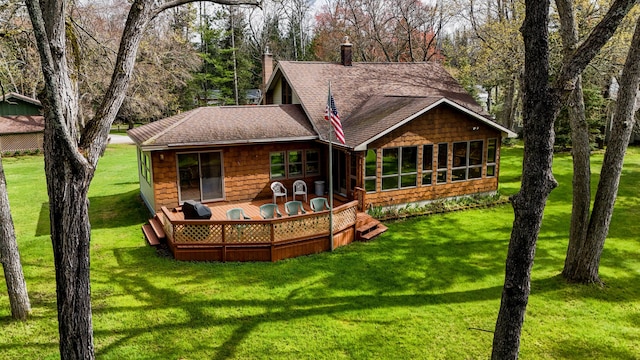 370 W Park Dr, Grayling, MI 49738 - rear view of house with a shingled roof, a sunroom, a chimney, a deck, and a yard