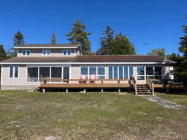 3199 S Lake Shore Dr, Bois Blanc, MI 49775 - back of property featuring a lawn and a deck