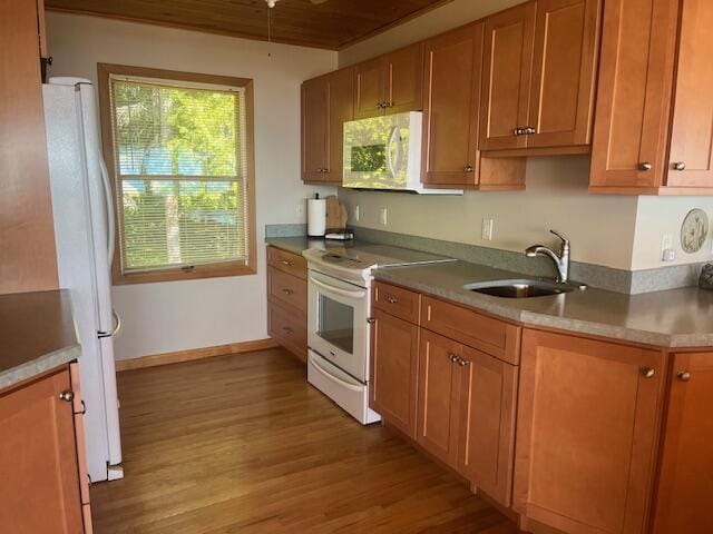 3199 S Lake Shore Dr, Bois Blanc, MI 49775 - kitchen featuring white appliances, wood finished floors, a sink, and brown cabinetry