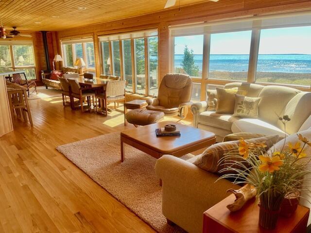3199 S Lake Shore Dr, Bois Blanc, MI 49775 - living area with wood ceiling, ceiling fan, light wood-style flooring, and wooden walls