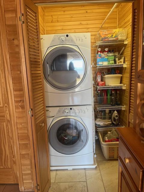 3199 S Lake Shore Dr, Bois Blanc, MI 49775 - laundry room featuring estacked washer and dryer and wood walls