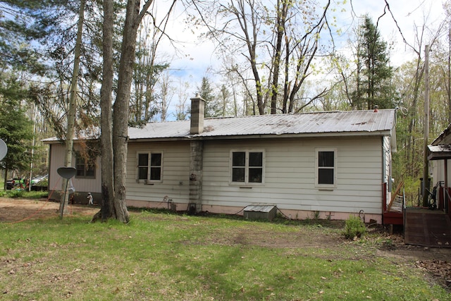 4541 Wills Rd, Lewiston, MI 49756 - rear view of property with a chimney, metal roof, a yard, and crawl space