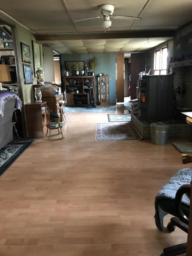 4541 Wills Rd, Lewiston, MI 49756 - living room with a wood stove, wood finished floors, and ceiling fan
