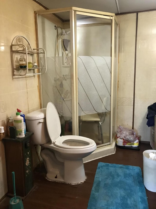 4541 Wills Rd, Lewiston, MI 49756 - bathroom featuring tile walls, toilet, a shower stall, and wood finished floors