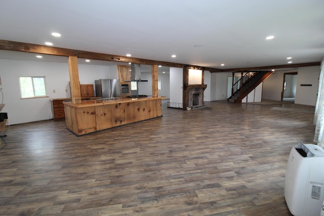 7844 Gilbert Trl, Grayling, MI 49738 - kitchen with stainless steel appliances, open floor plan, recessed lighting, dark wood-type flooring, and wall chimney range hood