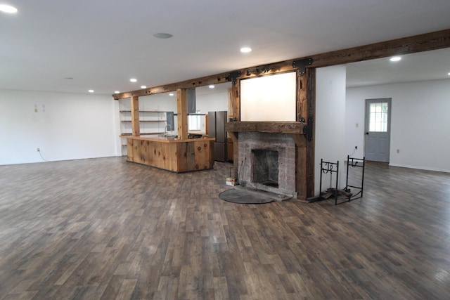 7844 Gilbert Trl, Grayling, MI 49738 - unfurnished living room with dark wood-style flooring, recessed lighting, a large fireplace, and a sink
