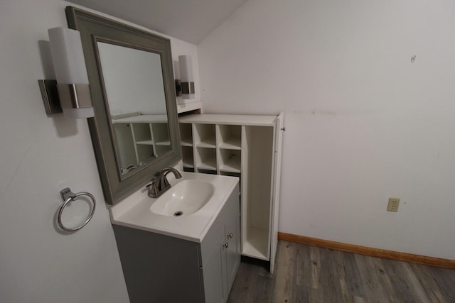 7844 Gilbert Trl, Grayling, MI 49738 - bathroom with wood finished floors, lofted ceiling, vanity, and baseboards