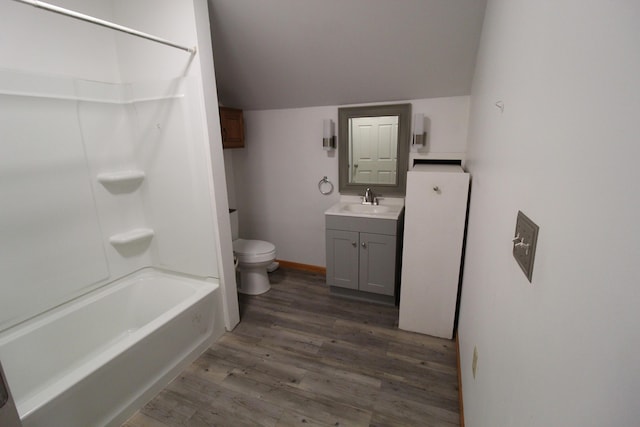 7844 Gilbert Trl, Grayling, MI 49738 - full bath featuring wood finished floors, vanity, toilet,  shower combination, and vaulted ceiling