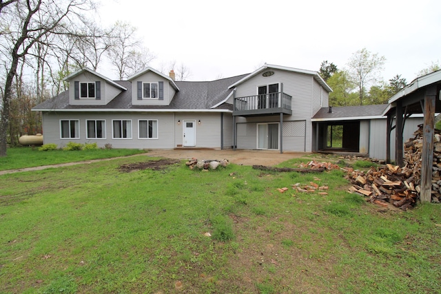 7844 Gilbert Trl, Grayling, MI 49738 - rear view of house with a balcony, a patio area, a yard, and roof with shingles