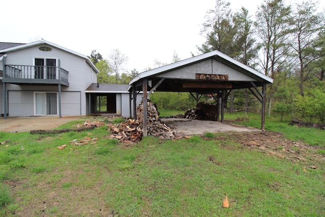 7844 Gilbert Trl, Grayling, MI 49738 - view of grassy yard with a balcony, driveway, and a detached carport