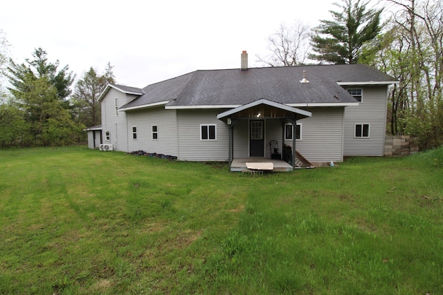 7844 Gilbert Trl, Grayling, MI 49738 - rear view of house featuring a yard, a chimney, and a shingled roof