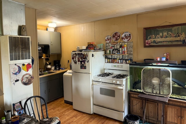 212 Scott St, Grayling, MI 49738 - kitchen with white appliances, light wood finished floors, washer / dryer, a sink, and a heating unit