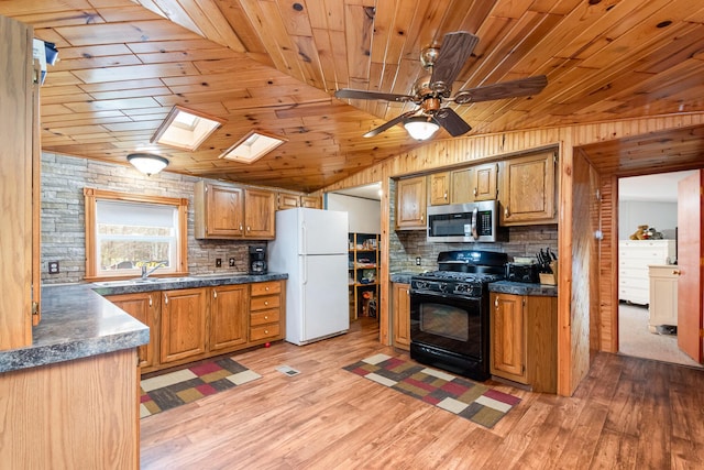 3357 E N Down River Rd, Grayling, MI 49738 - kitchen featuring freestanding refrigerator, gas stove, stainless steel microwave, wooden ceiling, and dark countertops