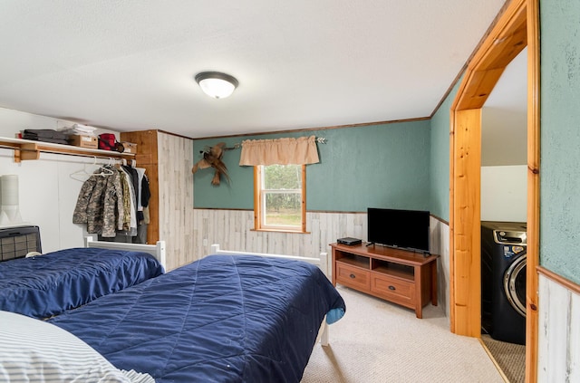 3357 E N Down River Rd, Grayling, MI 49738 - bedroom with carpet floors, wood walls, a wainscoted wall, and washer / dryer