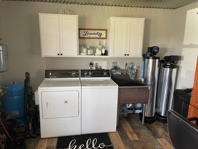 7557 Loop Rd, Posen, MI 49776 - laundry room with cabinet space, independent washer and dryer, and dark wood-style floors
