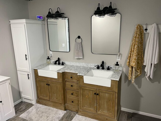 7557 Loop Rd, Posen, MI 49776 - full bathroom featuring double vanity, wood finished floors, and baseboards