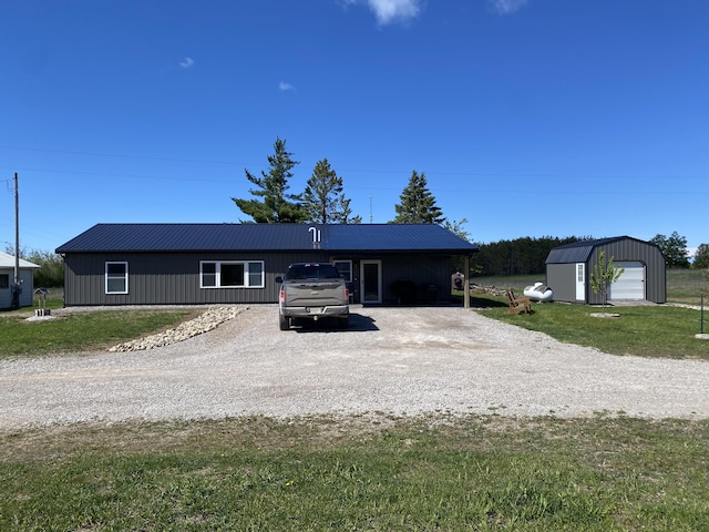 7557 Loop Rd, Posen, MI 49776 - single story home featuring gravel driveway, an outbuilding, a front yard, and metal roof