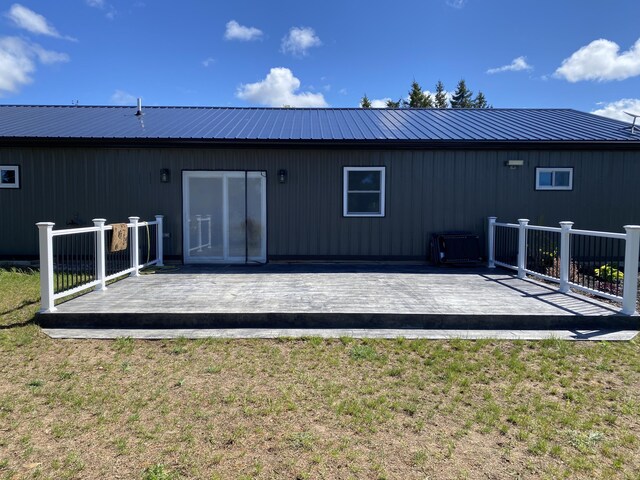 7557 Loop Rd, Posen, MI 49776 - rear view of property featuring a lawn, a deck, and metal roof