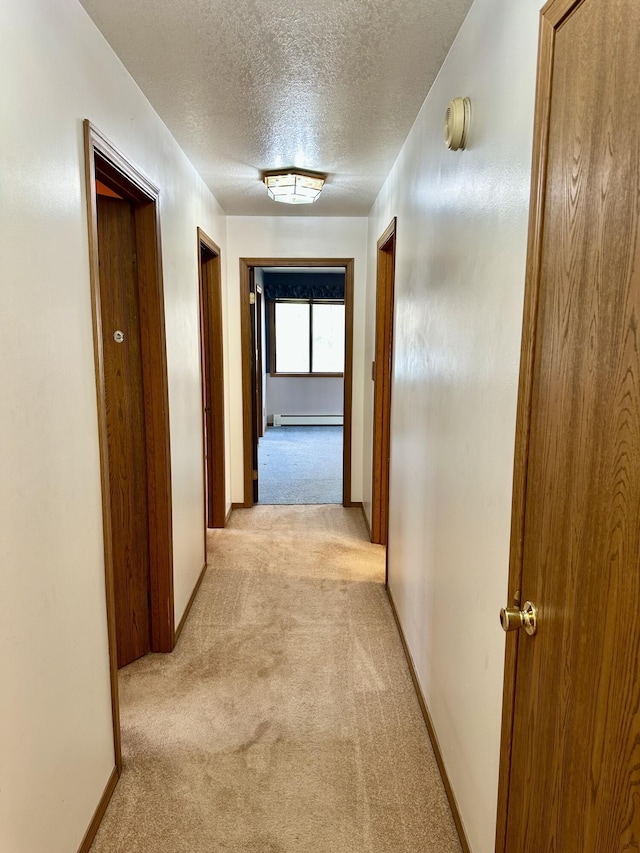 11030 S Stephan Bridge Rd, Roscommon, MI 48653 - corridor with light carpet, a baseboard radiator, a textured ceiling, and baseboards