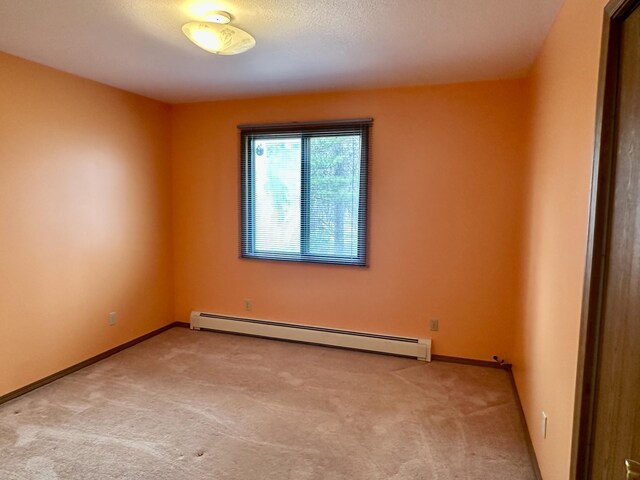 11030 S Stephan Bridge Rd, Roscommon, MI 48653 - unfurnished room featuring a baseboard radiator, carpet, and baseboards