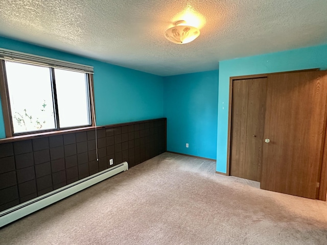 11030 S Stephan Bridge Rd, Roscommon, MI 48653 - unfurnished bedroom with a baseboard heating unit, carpet flooring, a closet, and a textured ceiling
