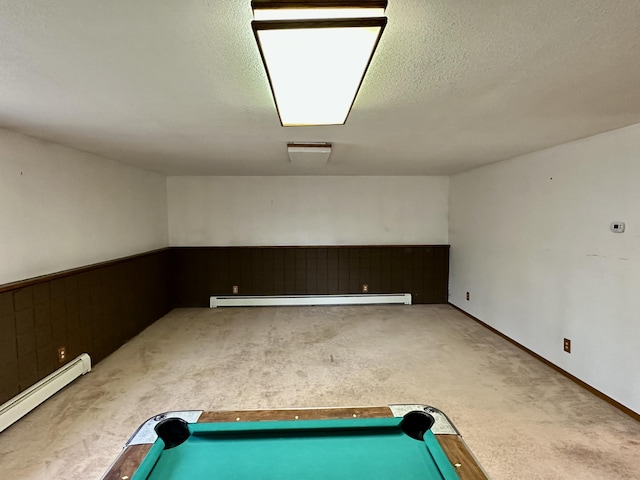 11030 S Stephan Bridge Rd, Roscommon, MI 48653 - below grade area with a baseboard radiator, a baseboard heating unit, carpet floors, a wainscoted wall, and a textured ceiling