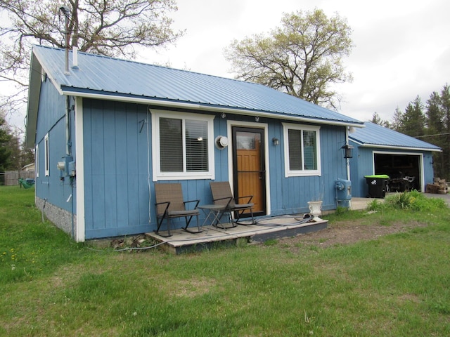 2020 Douglas Dr, Saint Helen, MI 48656 - back of house with a lawn, metal roof, and a garage