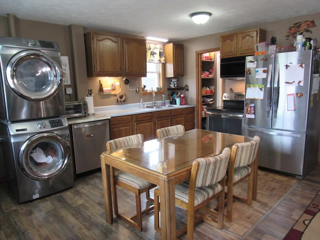 2020 Douglas Dr, Saint Helen, MI 48656 - kitchen with appliances with stainless steel finishes, stacked washer / dryer, a sink, light countertops, and brown cabinets