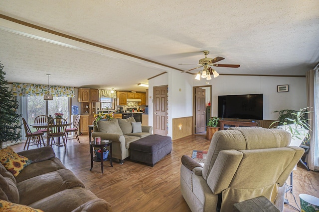 398 Vale St, Cheboygan, MI 49721 - living area featuring a textured ceiling, a ceiling fan, wood finished floors, wainscoting, and ornamental molding