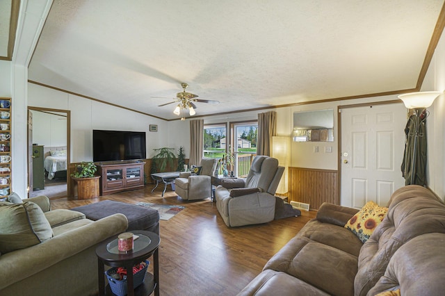 398 Vale St, Cheboygan, MI 49721 - living room with ornamental molding, vaulted ceiling, wood finished floors, ceiling fan, and a wainscoted wall