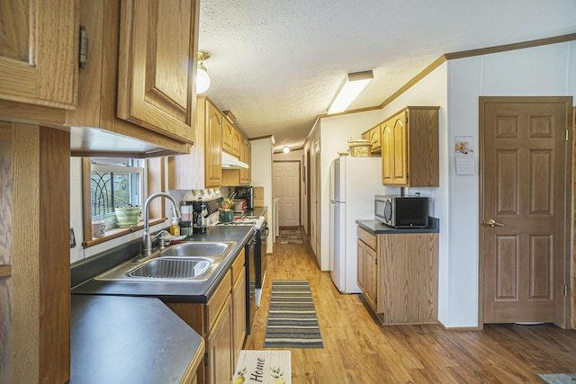 398 Vale St, Cheboygan, MI 49721 - kitchen with stainless steel microwave, a sink, under cabinet range hood, range with electric stovetop, and dark countertops