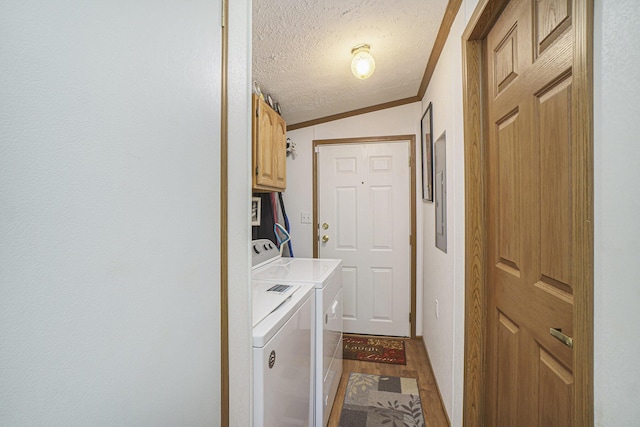 398 Vale St, Cheboygan, MI 49721 - laundry room with cabinet space, separate washer and dryer, a textured ceiling, and ornamental molding