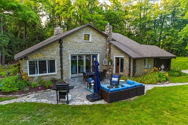 4423 Island View Dr, Gaylord, MI 49735 - back of house featuring a chimney, a patio, stone siding, and a lawn