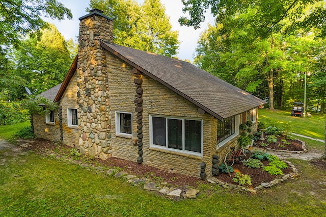 4423 Island View Dr, Gaylord, MI 49735 - view of home's exterior featuring stone siding, a chimney, a lawn, and roof with shingles