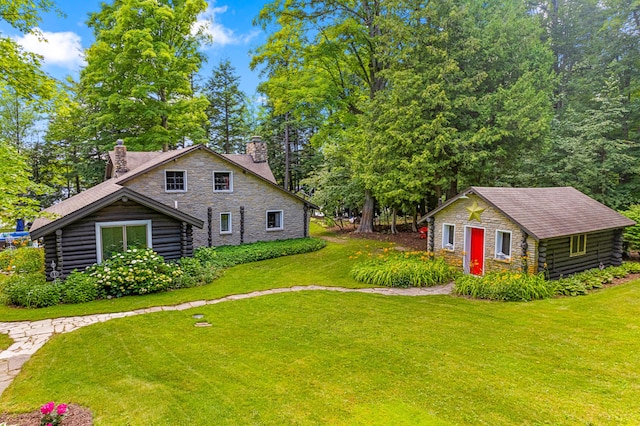 4423 Island View Dr, Gaylord, MI 49735 - view of side of property featuring a chimney, a yard, stone siding, log exterior, and an outdoor structure