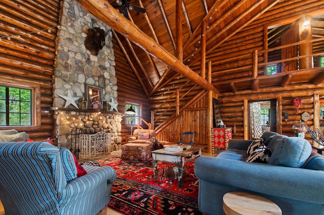 4423 Island View Dr, Gaylord, MI 49735 - living room with high vaulted ceiling, log walls, a fireplace, and wooden ceiling with exposed beams