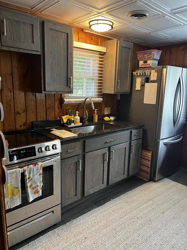 1828 Higgins, Saint Helen, MI 48656 - kitchen featuring stainless steel appliances, a sink, wood walls, an ornate ceiling, and dark stone counters