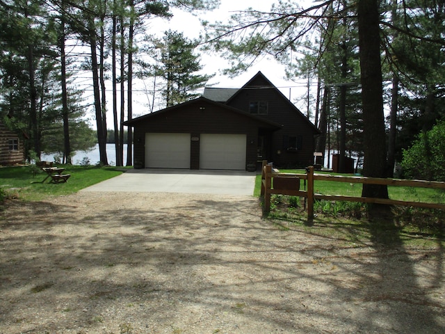 5622 Vacationland Dr, Lewiston, MI 49756 - view of front of home with concrete driveway, an attached garage, and a front lawn