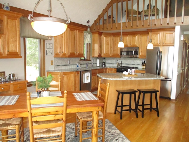5622 Vacationland Dr, Lewiston, MI 49756 - kitchen with stainless steel appliances, a sink, light wood finished floors, a center island, and backsplash